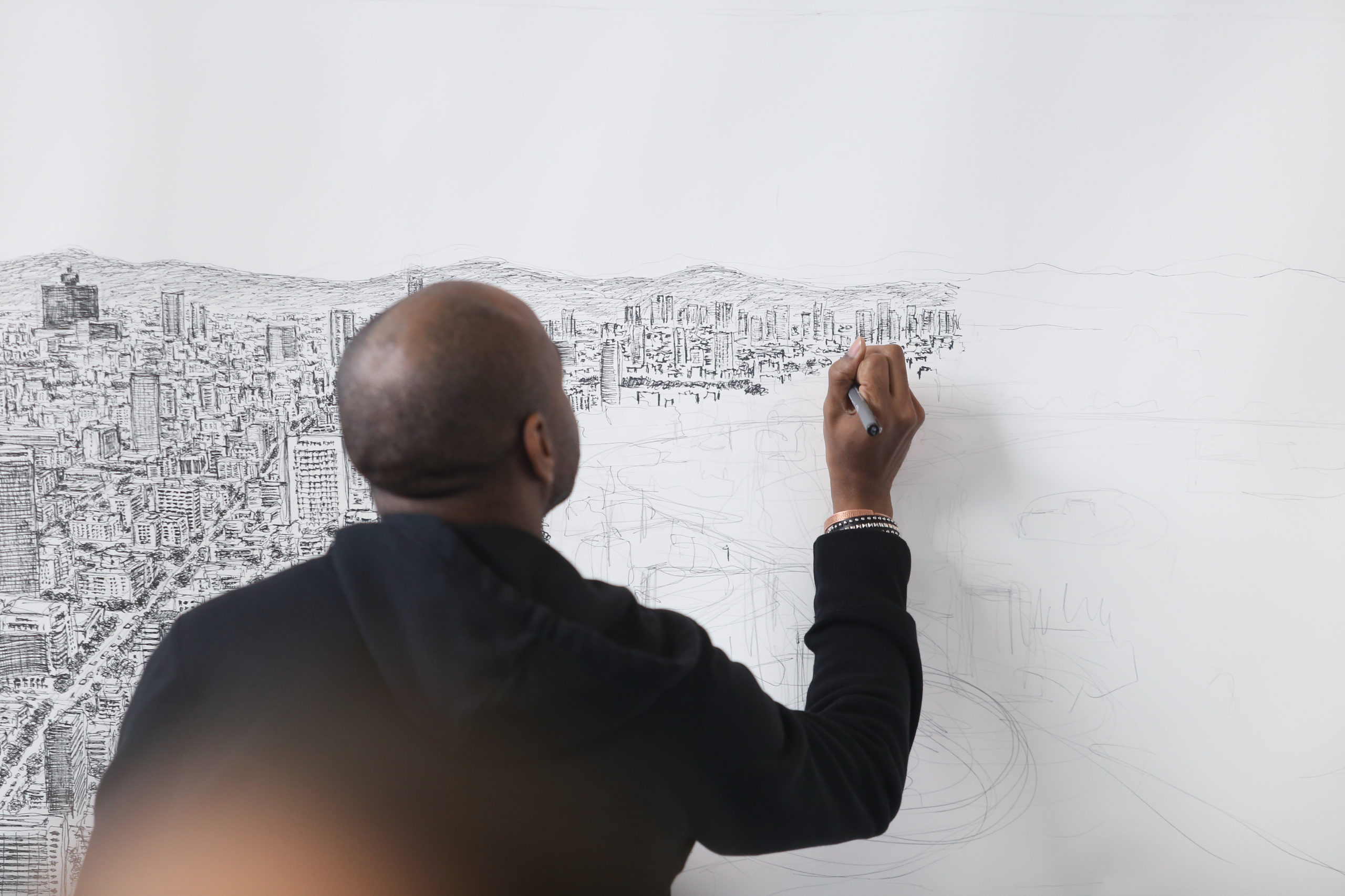 The artist Stephen Wiltshire is drawing a panoramic landscape.