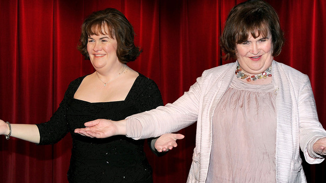 The singer Susan Boyle stands beside a waxwork model of herself.