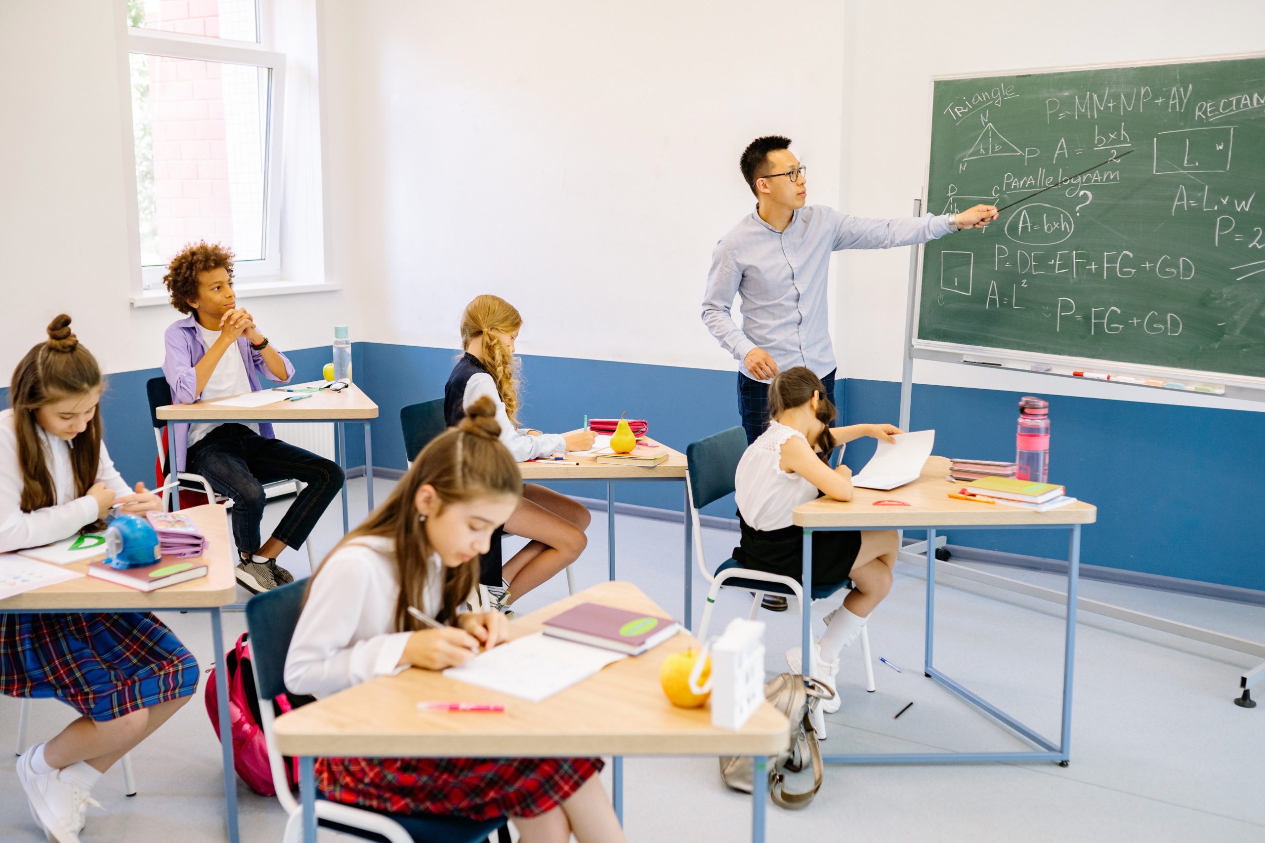 A teacher is teaching maths to a class of school students.
