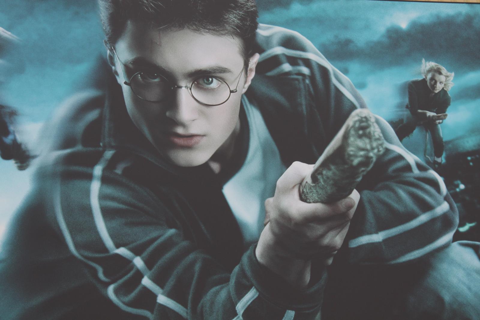 Daniel Radcliffe in the character of Harry Potter is flying on a broomstick.