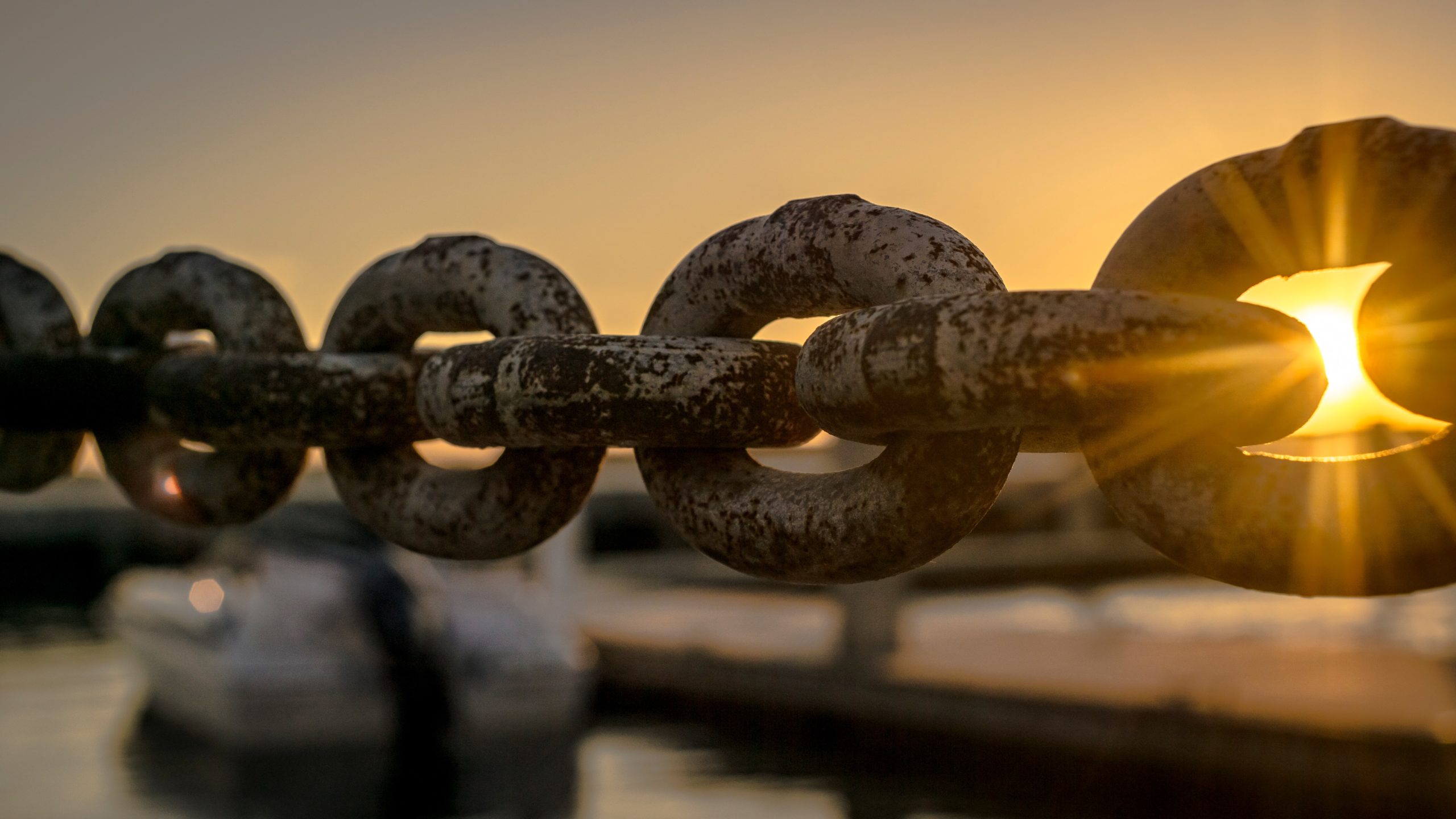 A metal chain in front of a sunrise sky