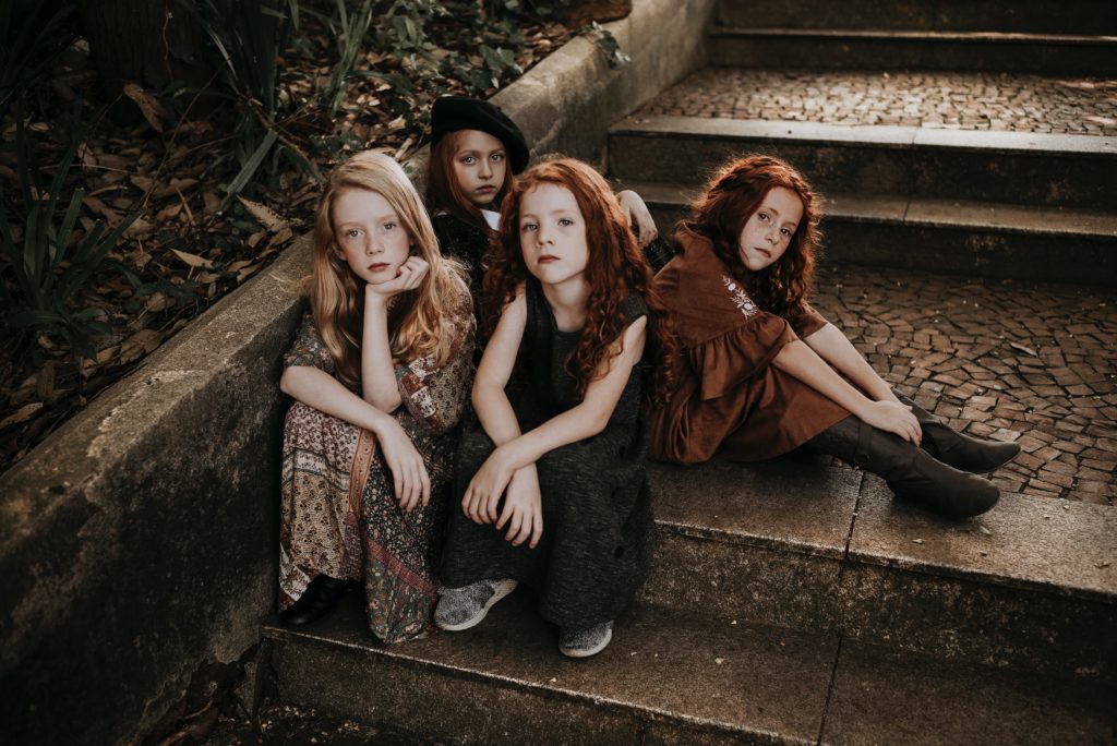 A group of girls are sitting on some outdoor steps.