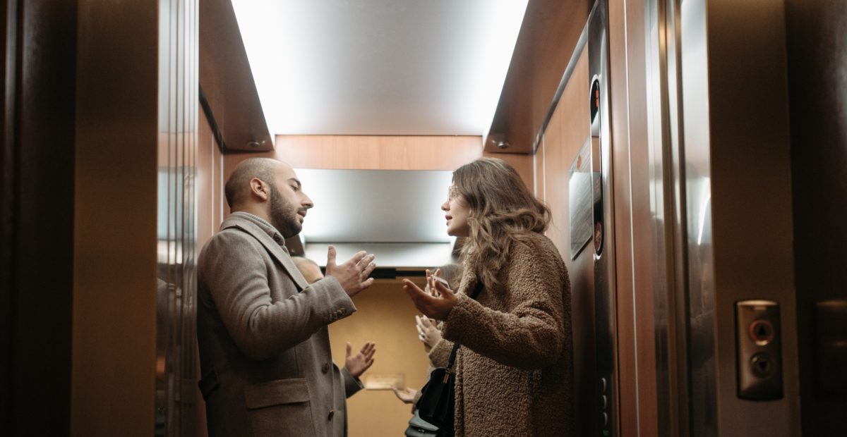 A man and a woman are arguing inside a lift or an elevator.