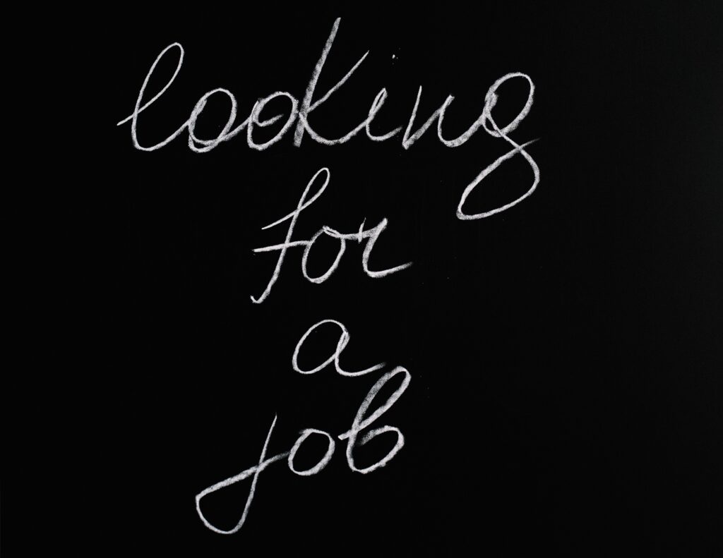 The words, "Looking for a job," are written on a chalkboard.