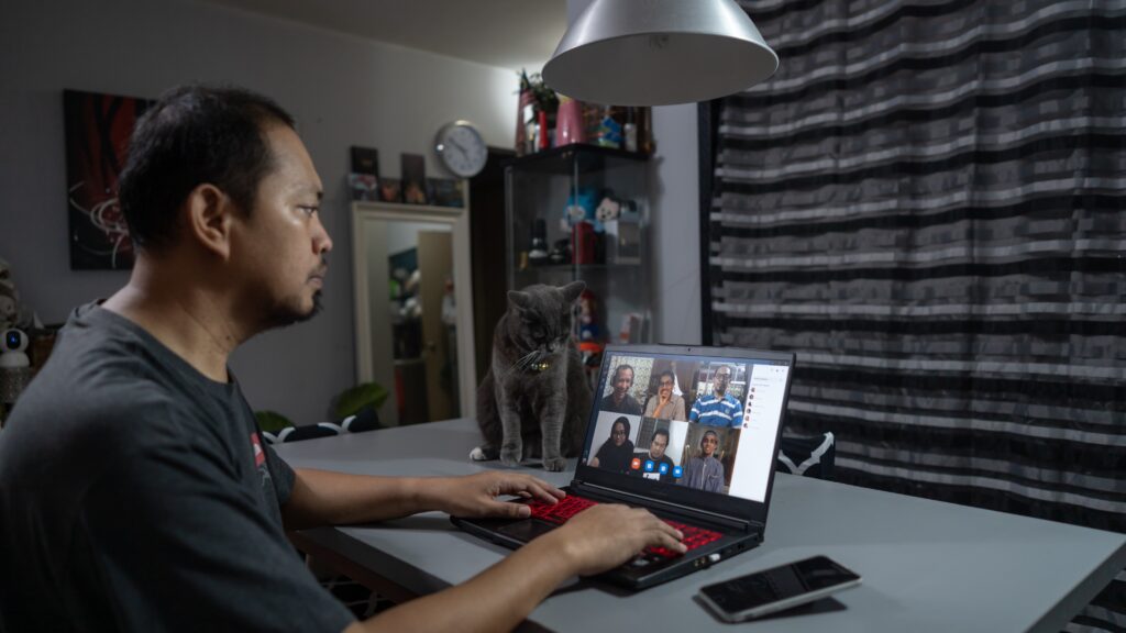 A man is taking part in a video call on his laptop.