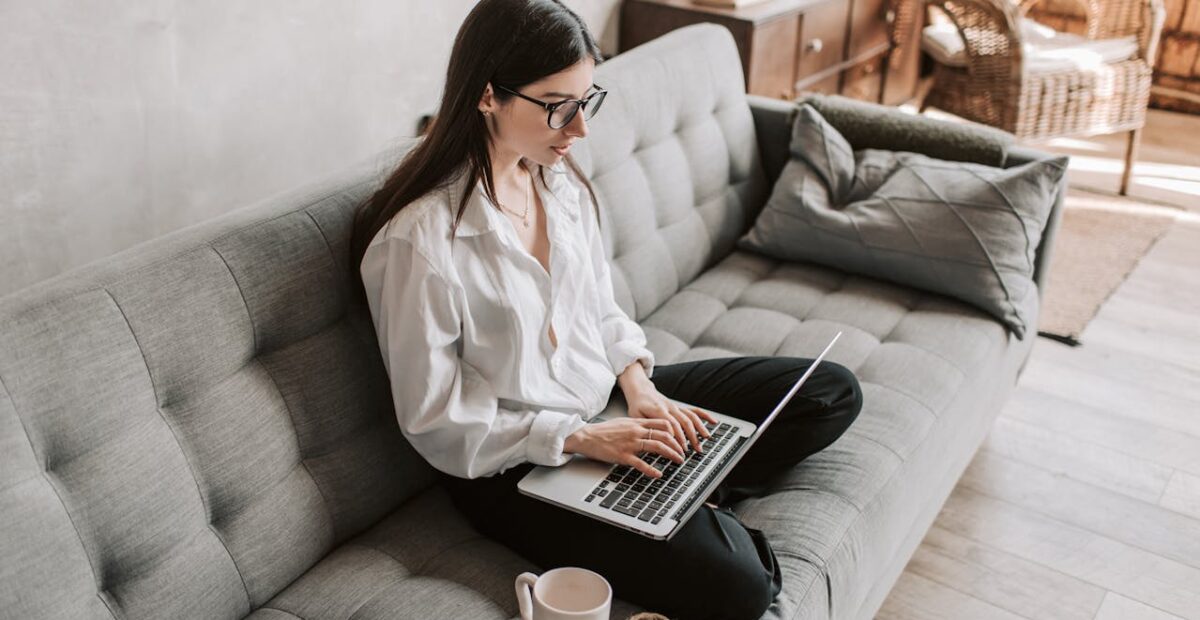 Alt text: Woman working comfortably from home on a laptop in a cozy setting