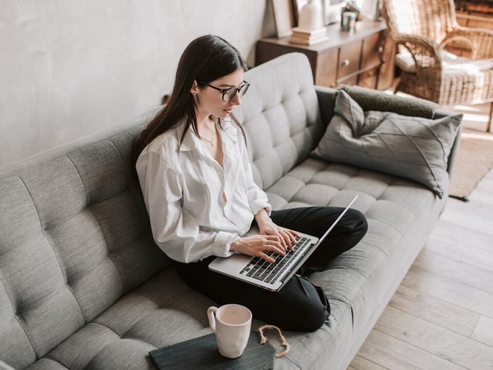 Alt text: Woman working comfortably from home on a laptop in a cozy setting