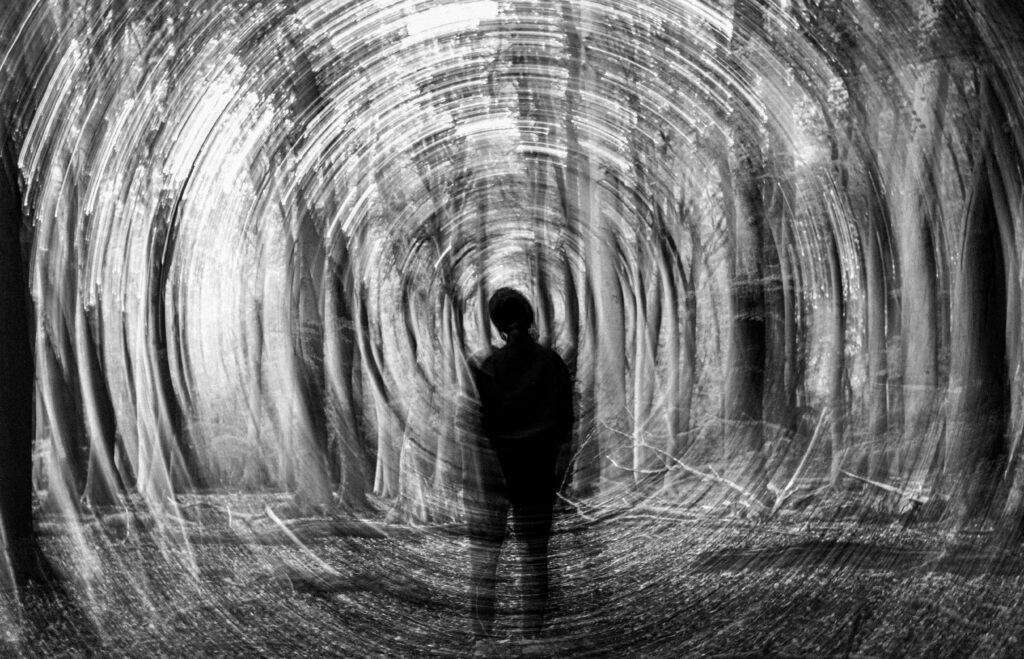Person standing inside a dark circular tunnel, representing the gap between policy and neuroinclusive workplace culture.
