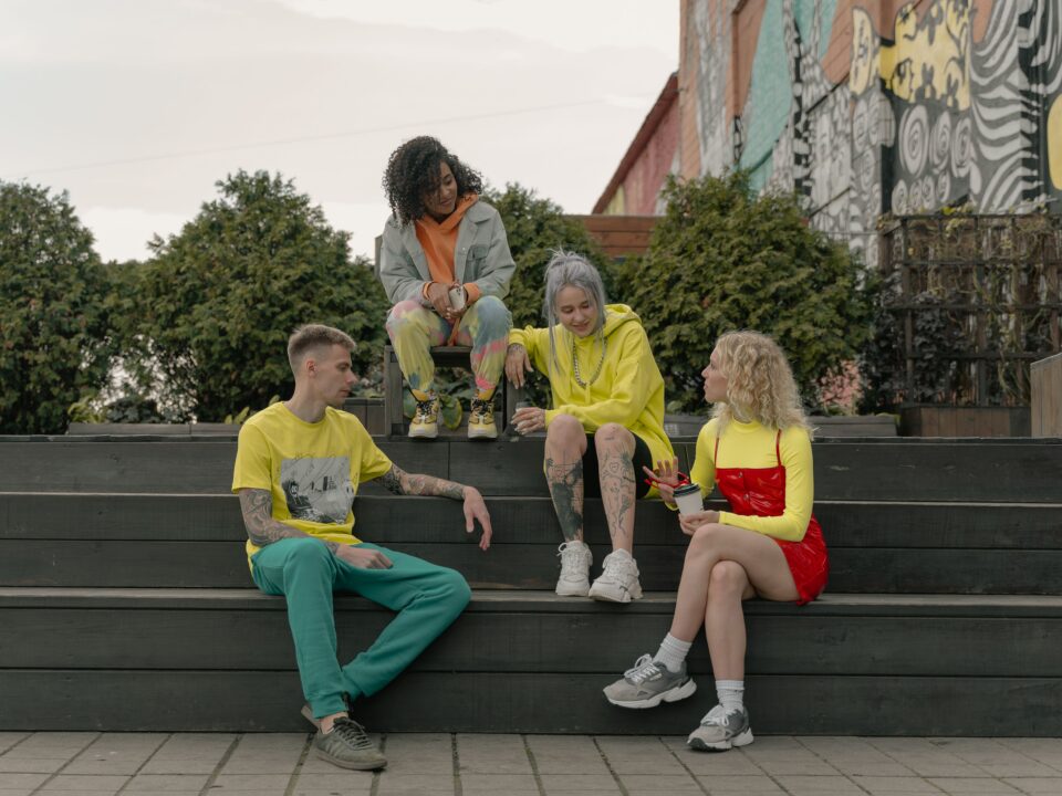 Young adults sitting together and talking on outdoor steps.
