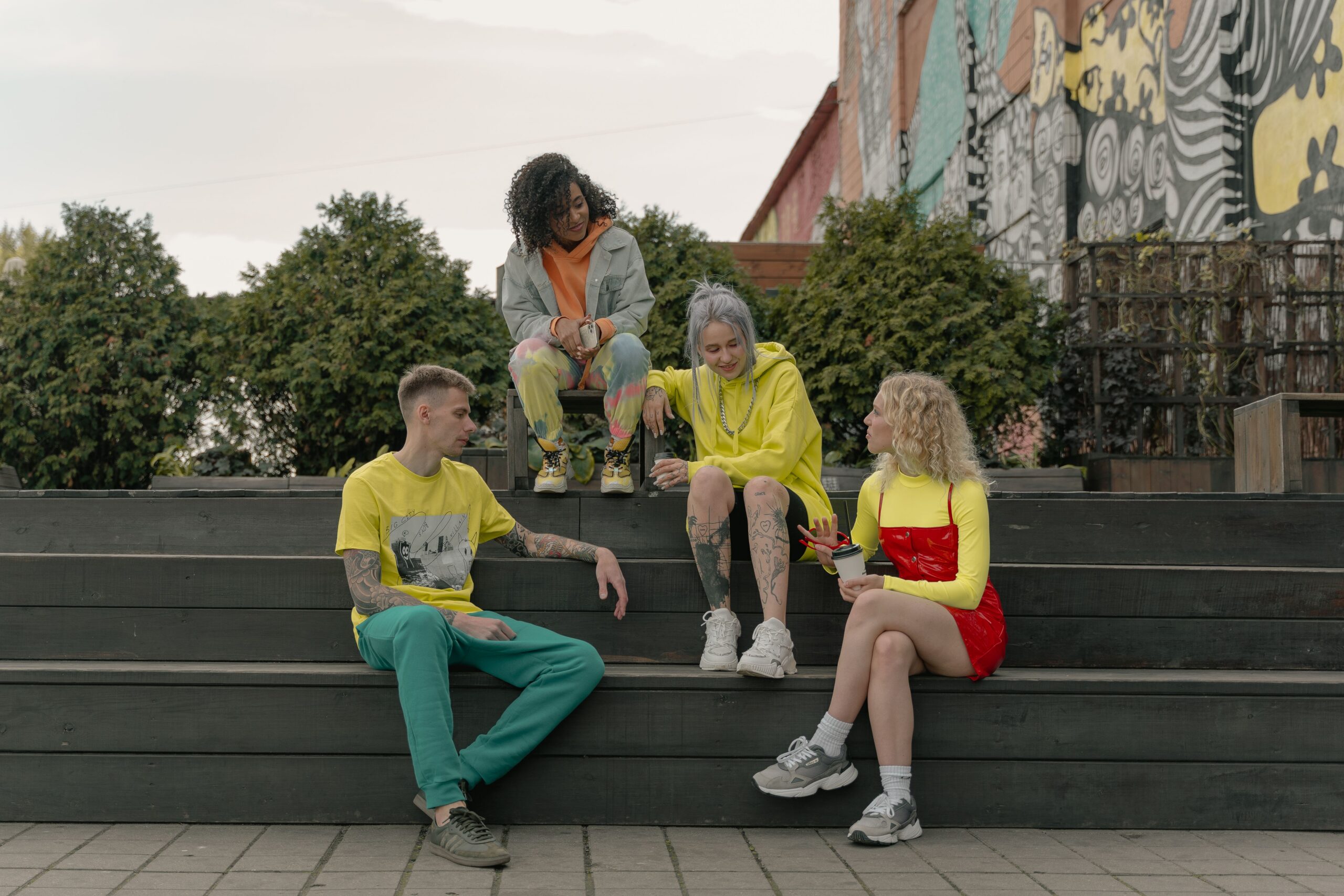 Young adults sitting together and talking on outdoor steps.